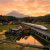 夕暮れの日本の田園風景の中を走り抜ける新幹線