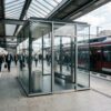 新幹線駅の明るいプラットホーム上に設置されたガラス張りのモダンな指定喫煙スペース